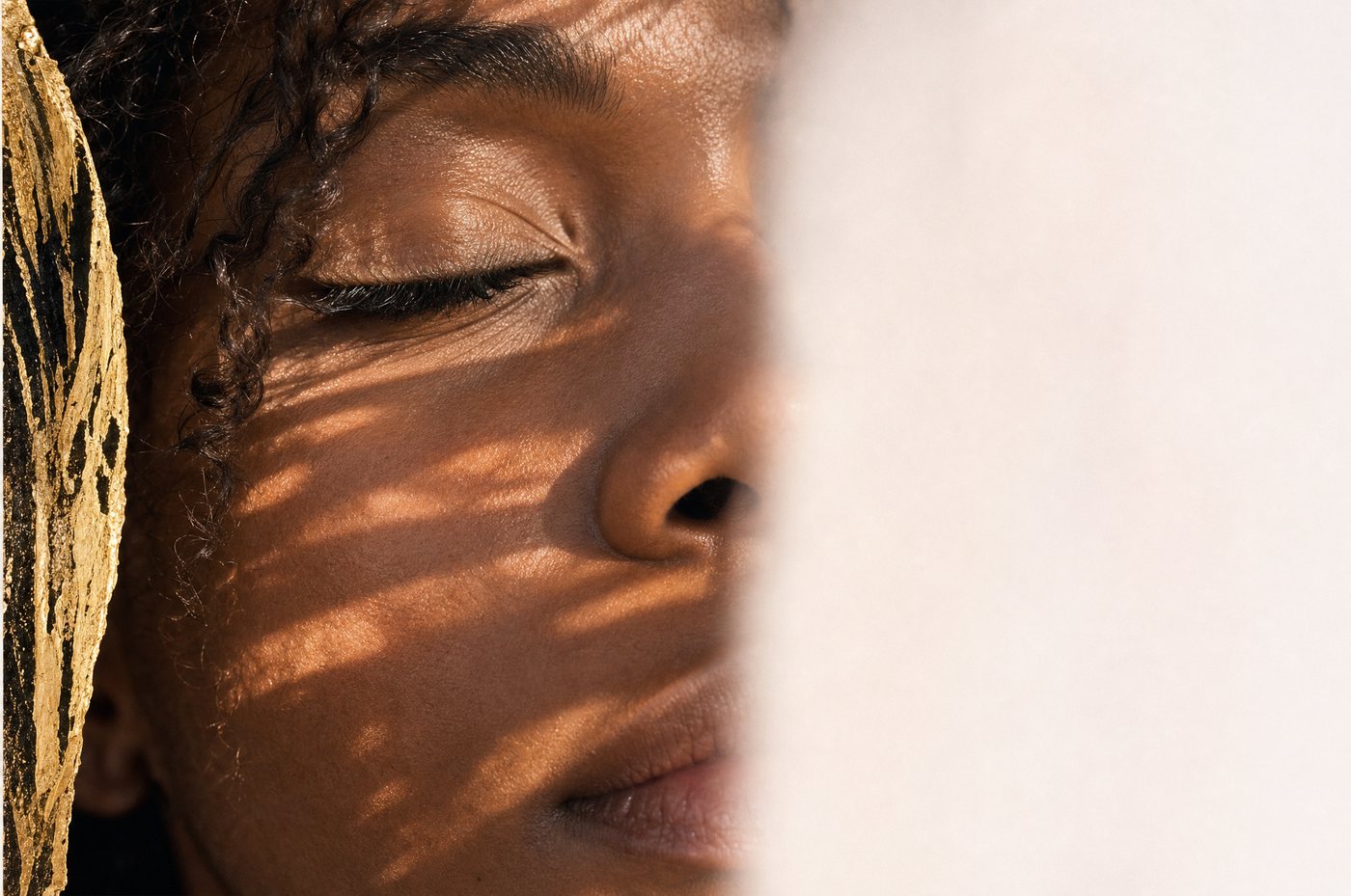Close-up of a woman with her eyes closed, sunlight on her skin